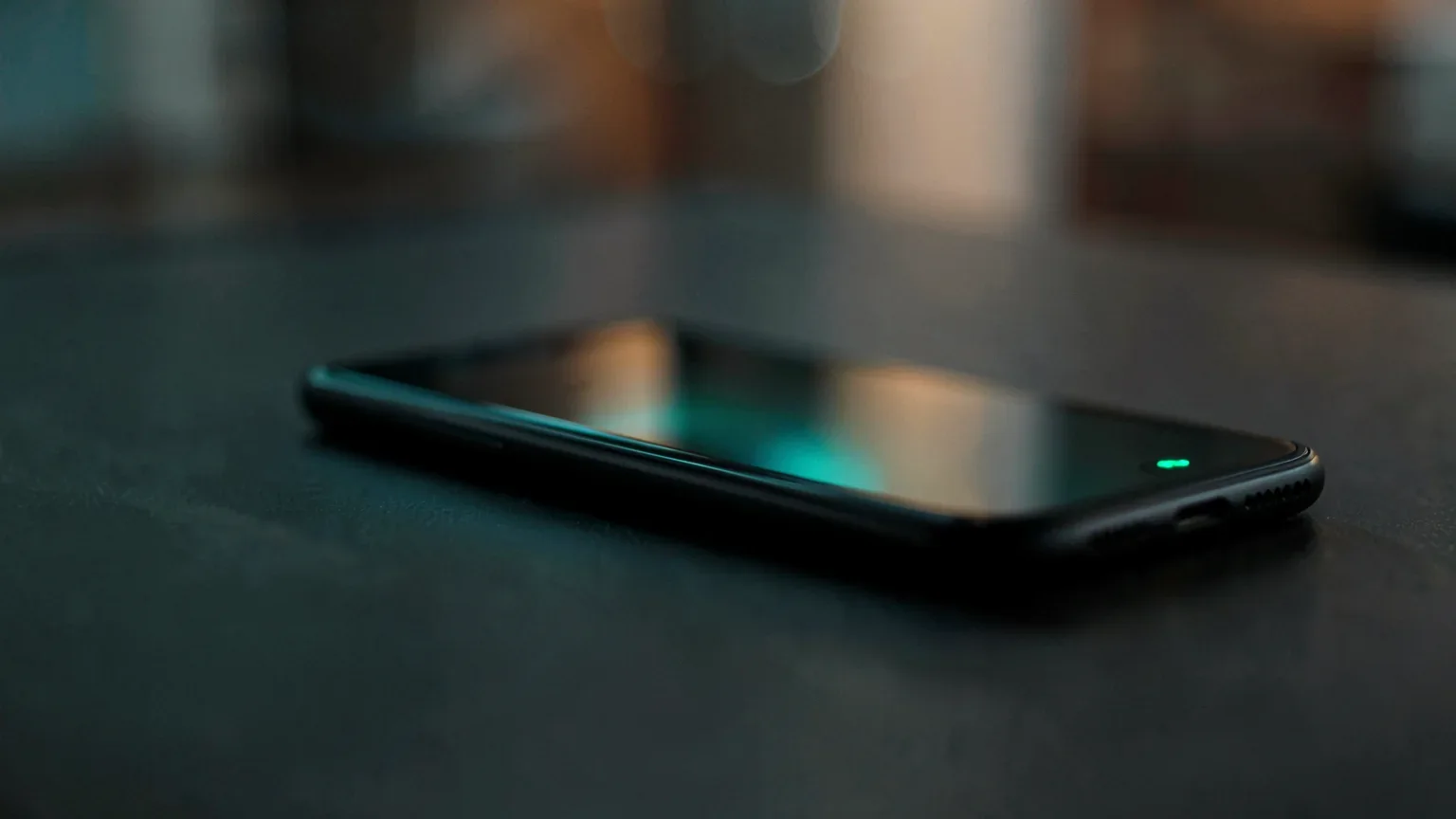 Smartphone auf dunklem Schreibtisch